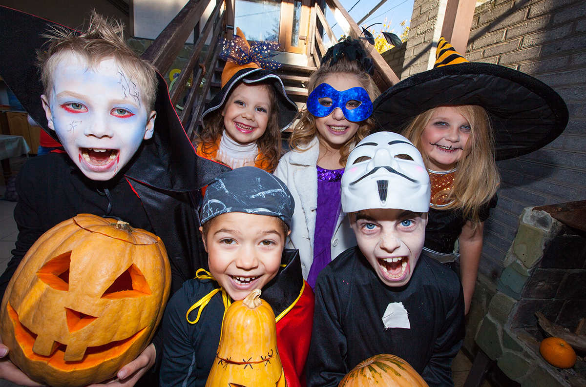 Children in halloween costumes show funny faces