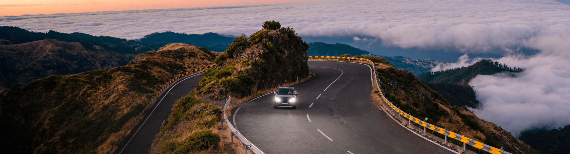 Car driving down mountainous road at night