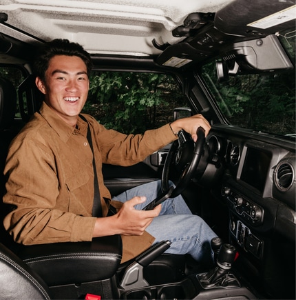 Person in driver's seat of car smiling