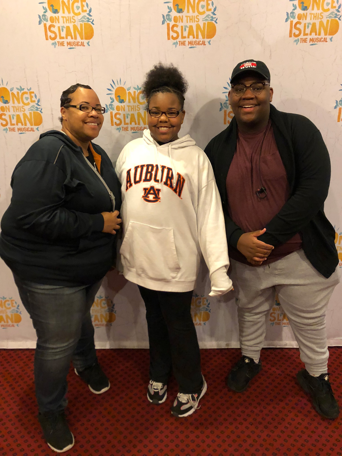 Family of three posing for a picture on a red carpet