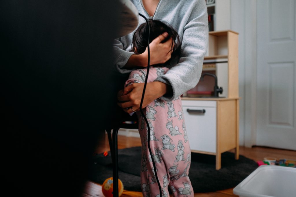 Parent hugging their toddler while working from home