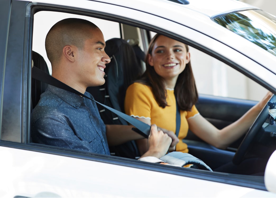 Two teenagers driving in a car