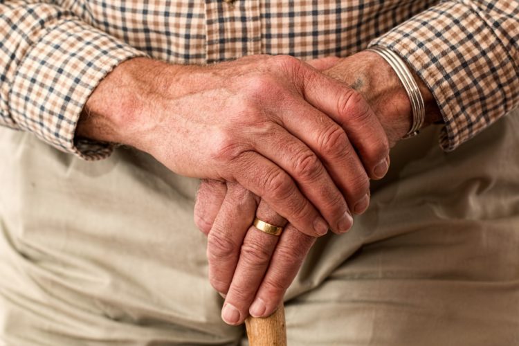 Old man's hands crossed over in front of him