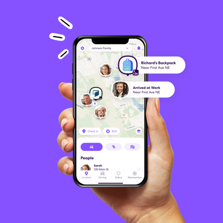 Hand holding smartphone showing Life360 app with people and items on map