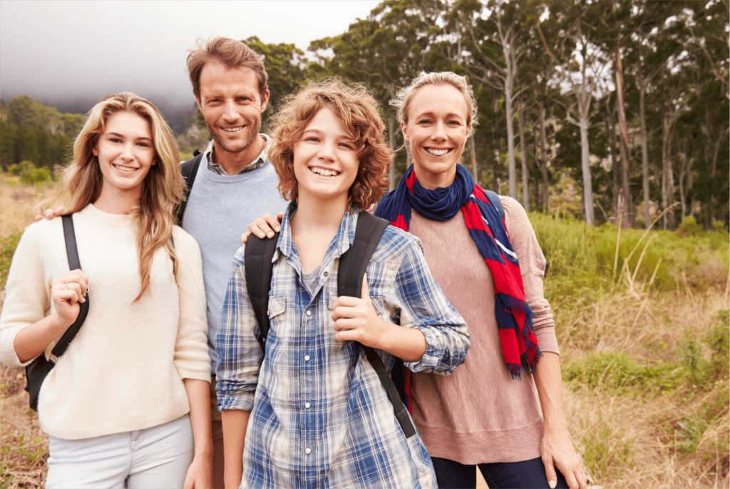 Family of four posing for a picture while on a hike