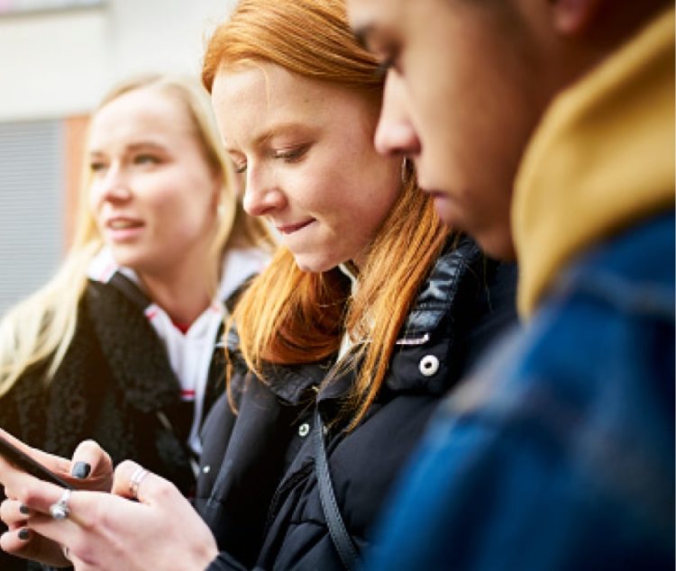 Teenagers looking at a cellphone