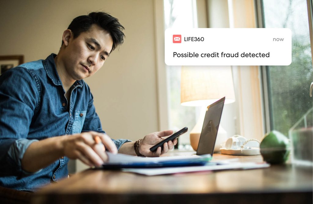 Man looking at papers when he receives a credit fraud alert from Life360