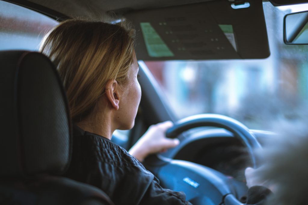 Backseat picture of a teen girl driving a car