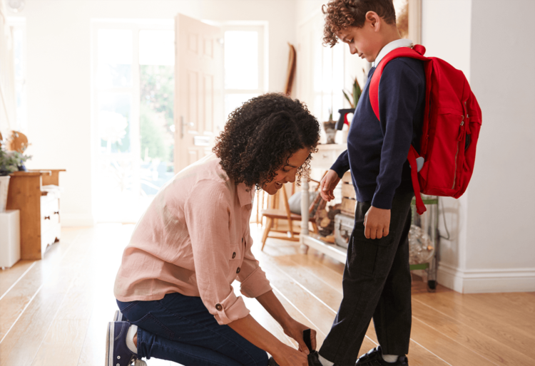 Mother tying her son's shoes