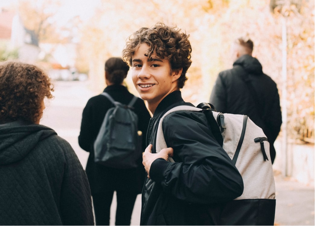 Boy with backpack looking over his shoulder