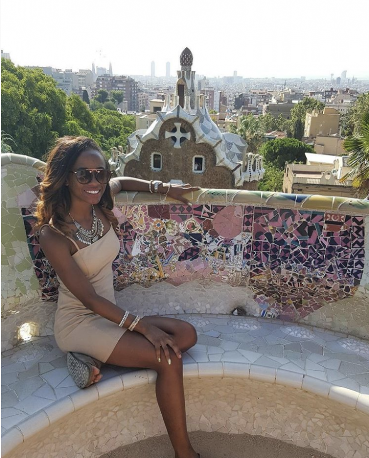 A woman smiling while sitting in front of the Barcelona skyline