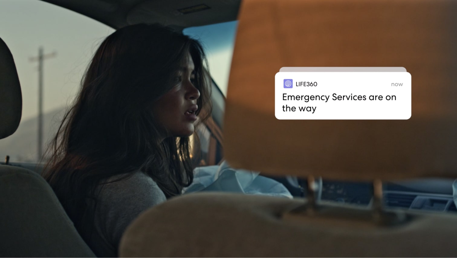 Image of worried woman in car with Life360 notification reading 